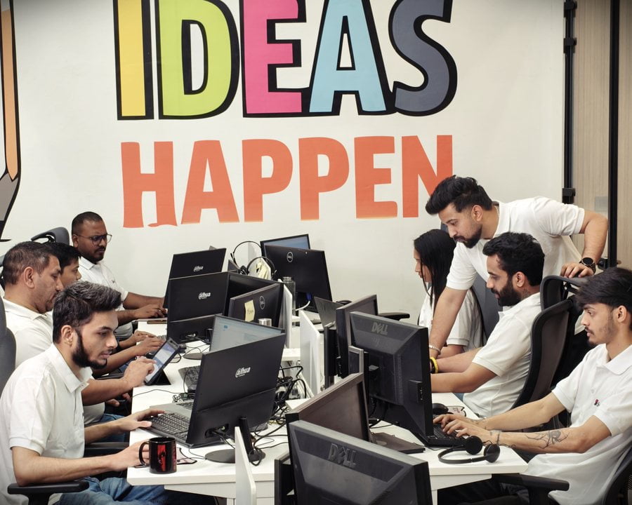 Swyft team at work under the Ideas Happen wall in our Mohali office